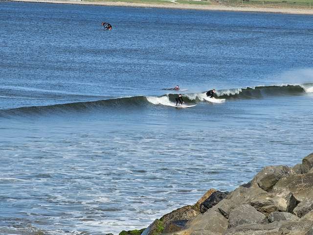 A couple of surfers catching a hip high wave on the main beach